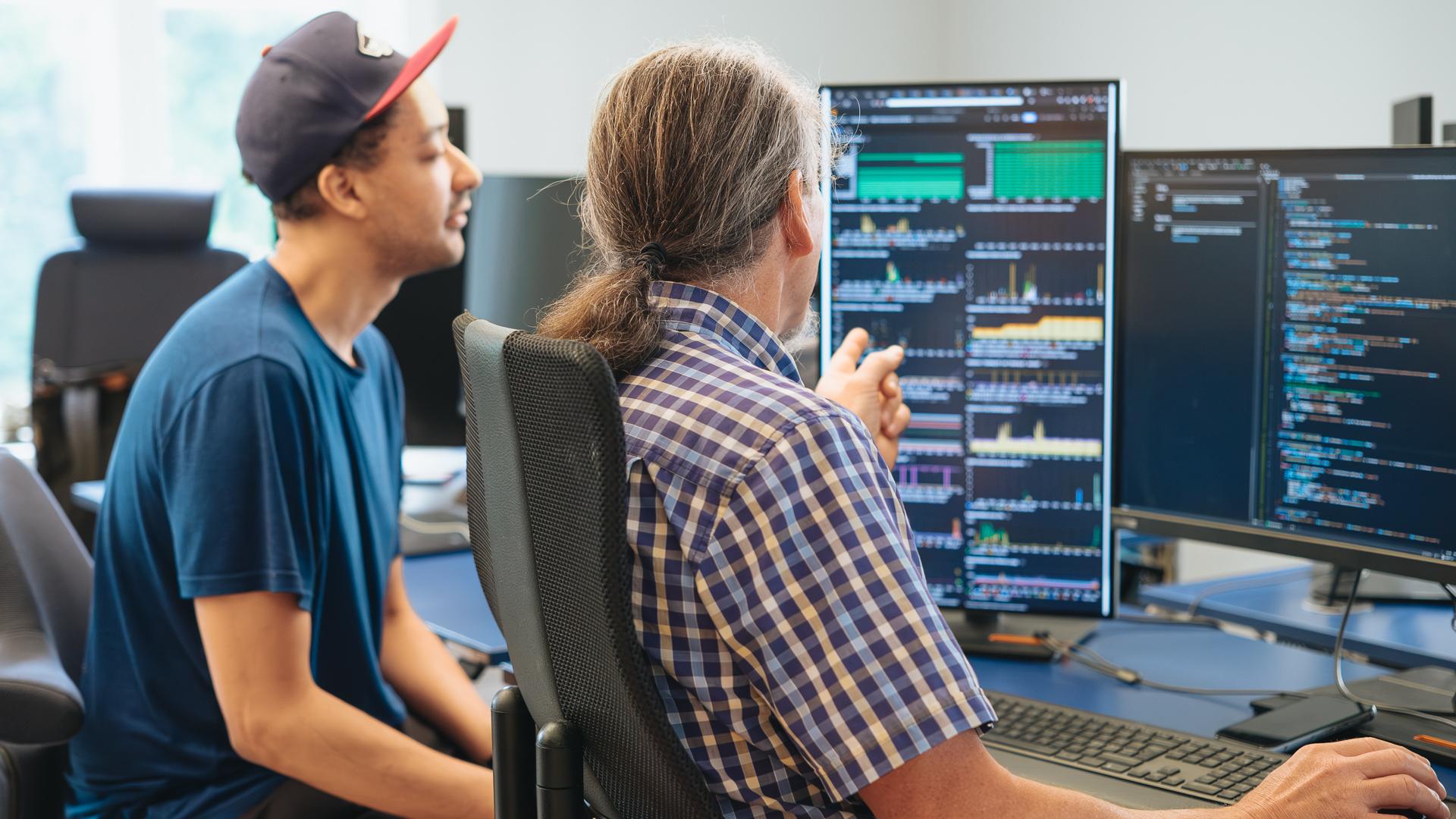 Developers analyzing in front of a dashboard with graphs